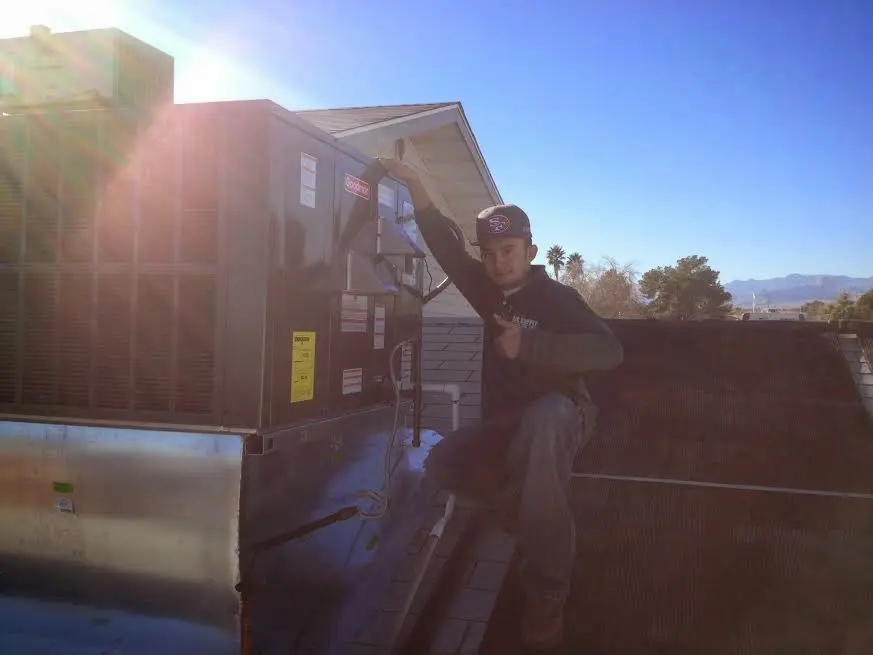 HVAC technician performing AC Tune-Up on a rooftop unit in Roeland Park